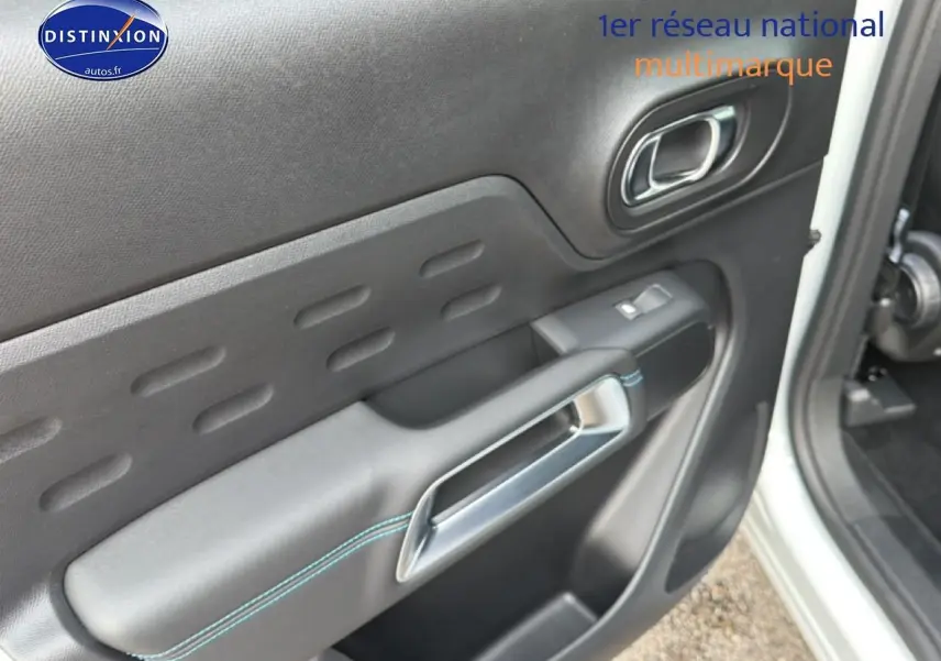 Détail de la porte avant droite noire avec surpiqûres bleues du Citroën C5 Aircross blanc 2025.