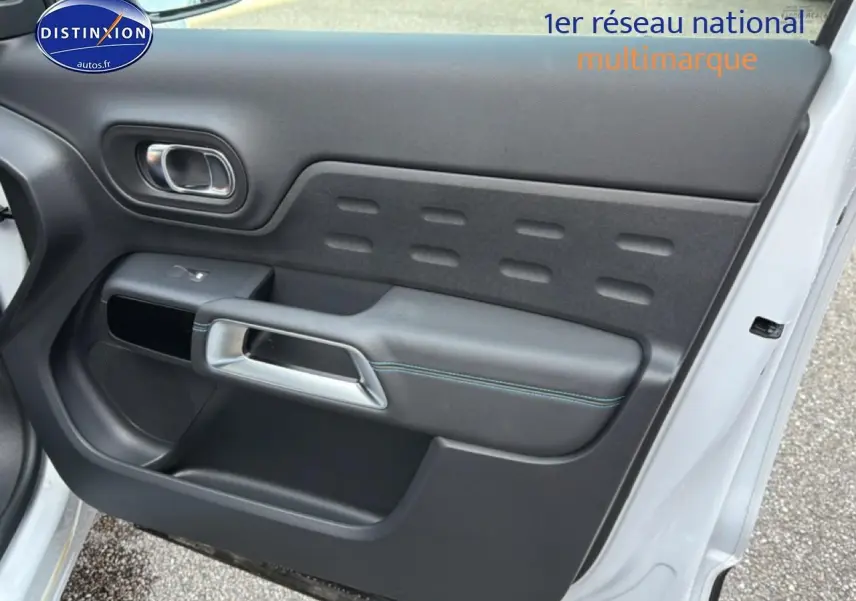 Vue rapprochée de la porte avant droite blanche d’un Citroën C5 Aircross 2025 avec garniture noire et poignée argentée.
