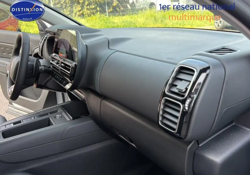 Vue intérieure côté passager du tableau de bord noir et gris avec écran tactile du Citroën C5 Aircross blanc 2025.