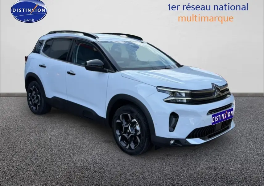 Citroën C5 Aircross blanc vue 3/4 avant droit avec jantes noires et barres de toit visibles.