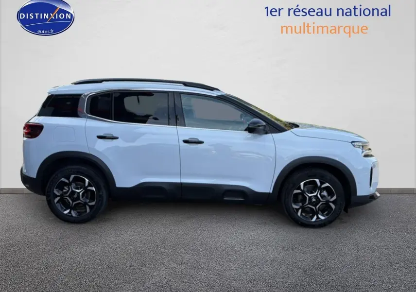 Profil droit d'un Citroën C5 Aircross blanc 2025 avec barres de toit et jantes alliage noires.