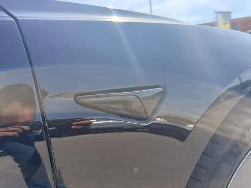 Détail du capteur latéral noir sur l'aile avant droite d'une Tesla Model 3 Standard RWD Plus 2022 noire.