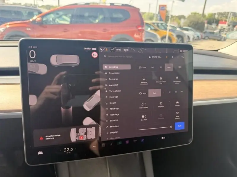 Écran tactile central du Tesla Model 3 noir 2022, vue intérieure sur le tableau de bord avec menu des réglages affiché.