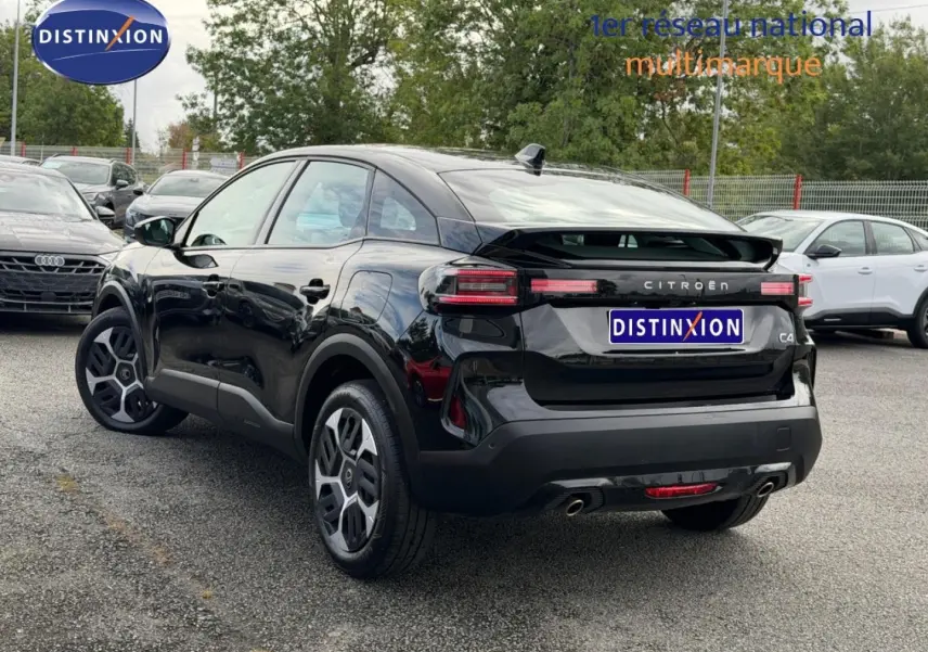 Citroën C4 hybride noire vue 3/4 arrière droit avec jantes alu et feux arrière LED distinctifs.