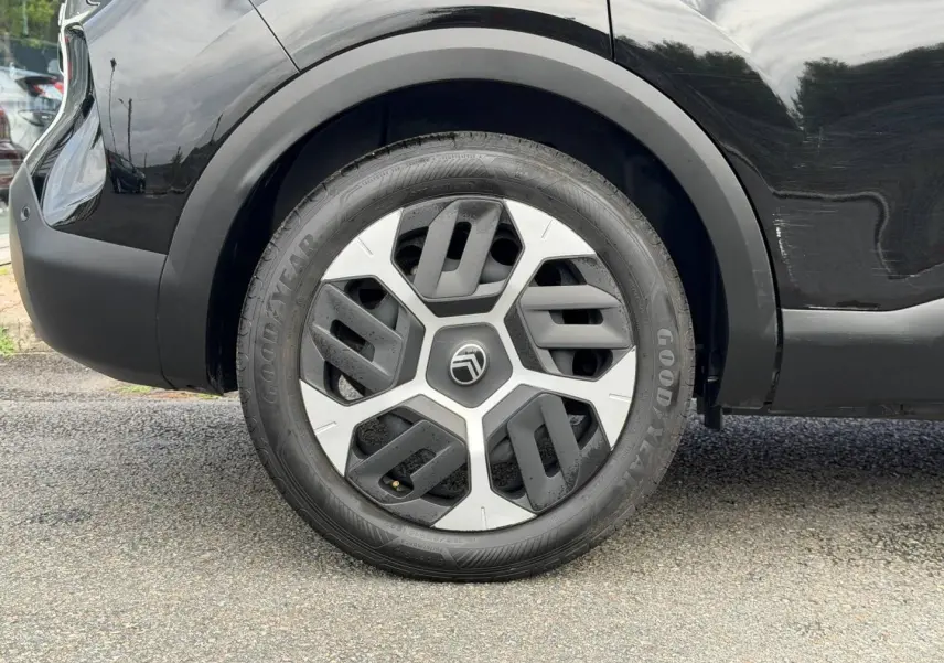 Gros plan sur la roue arrière droite noire Perla Nera d'une Citroën C4 1.2 Hybride avec jante alu distinctive.