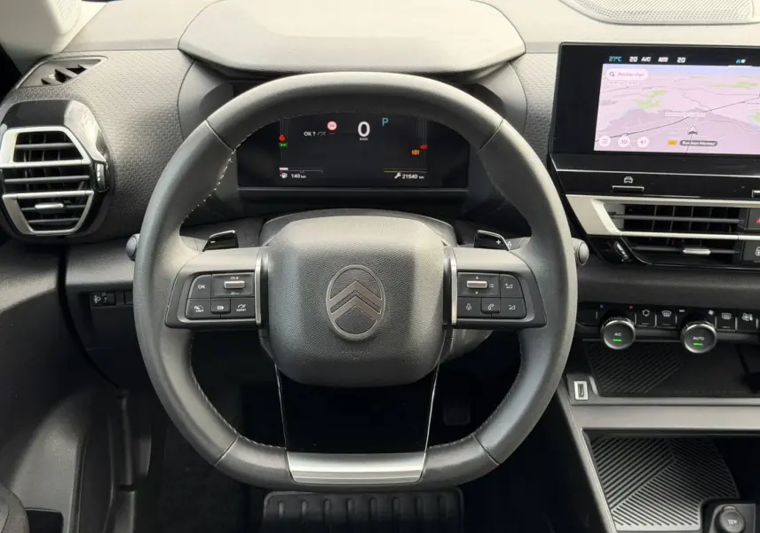 Vue frontale du volant cuir noir et du tableau de bord numérique de la Citroën C4 1.2 Hybride 2025 avec écran tactile GPS.