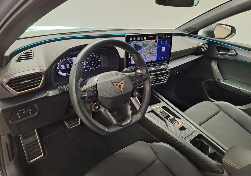 Vue intérieure côté conducteur de la CUPRA Leon 1.5 eTSI 2025 avec tableau de bord numérique et toit ouvrant panoramique.