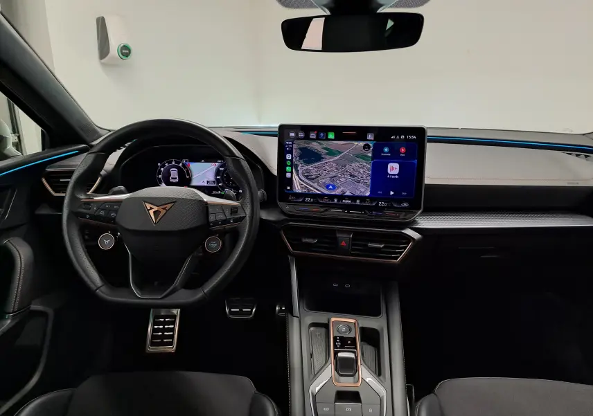 Vue intérieure avant du CUPRA Leon 1.5 eTSI 2025 avec tableau de bord numérique et écran tactile central lumineux.