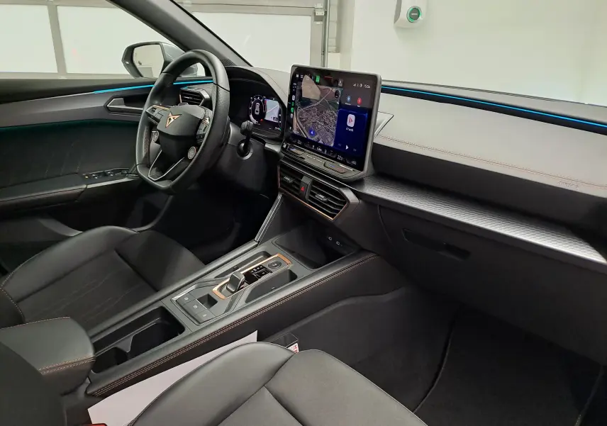 Vue intérieure côté conducteur de la CUPRA Leon 2025 avec tableau de bord numérique et écran tactile central.