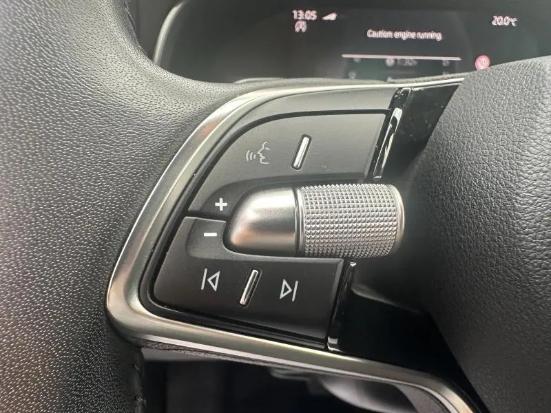 Gros plan sur les commandes multifonctions en noir et chrome du volant cuir d’une Skoda Scala 2025 noir Magic nacré.