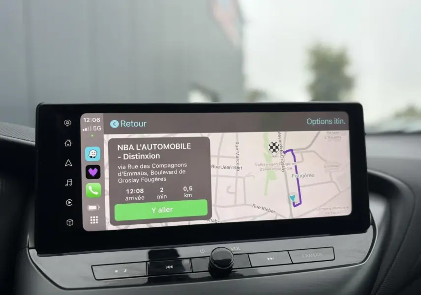 Écran tactile du système de navigation NissanConnect affichant un itinéraire dans l'habitacle du Nissan Juke blanc nacré.