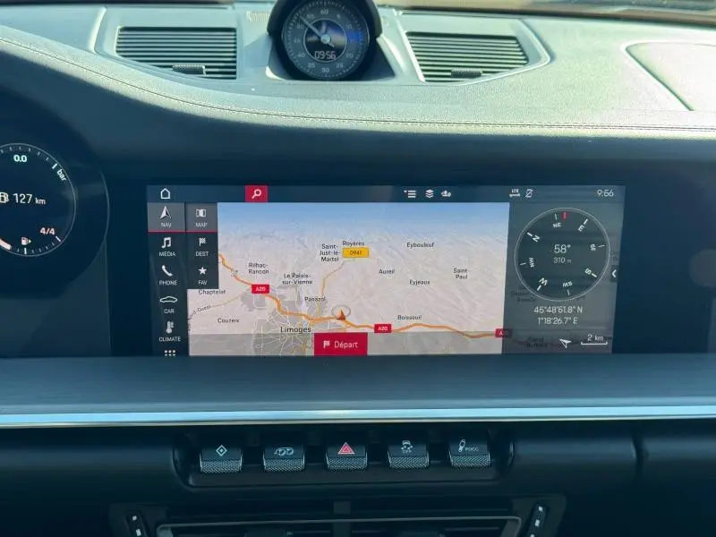 Vue rapprochée de l’écran tactile central et du tableau de bord noir d’une Porsche 911 Turbo S 2020 affichant un GPS en mode carte.