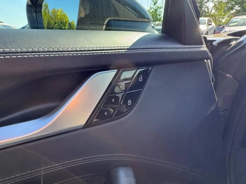Détail de la porte intérieure côté gauche en cuir noir avec commandes mémoire et poignée alu d'une Porsche 911 Turbo S 2020.