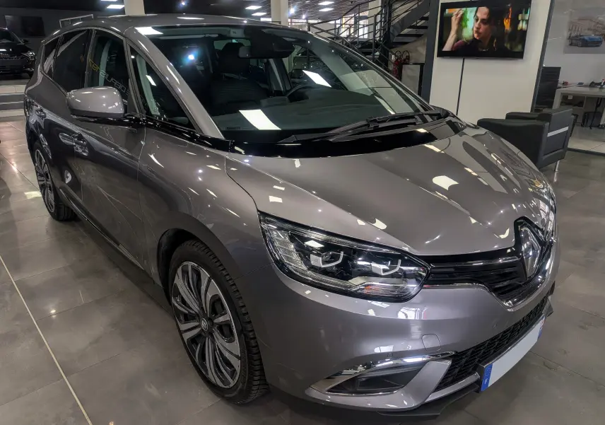 Vue 3/4 avant droit d’un Renault Grand Scénic IV gris Cassiopé, avec jantes alliage et éclairage LED distinctif.