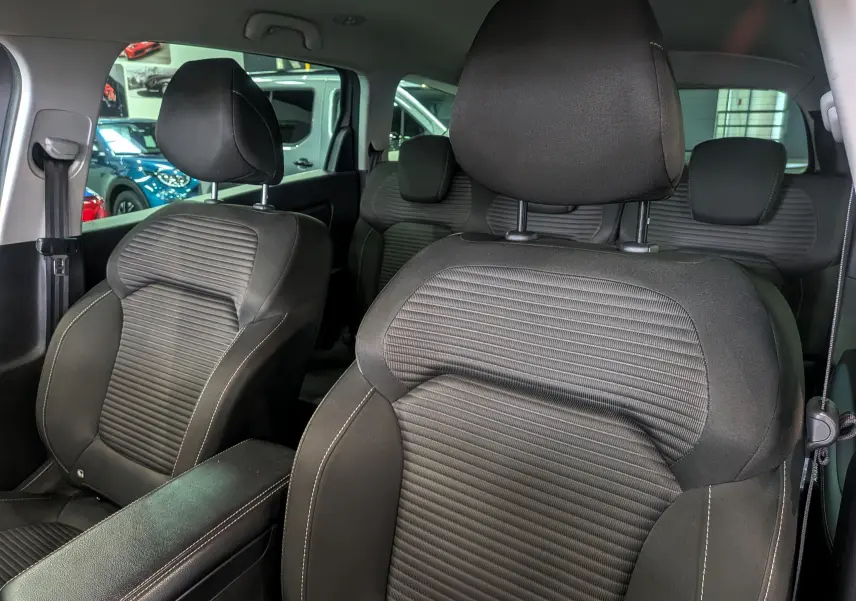 Vue intérieure rapprochée des sièges avant en tissu gris foncé du Renault Grand Scenic IV, version TCe 140 CH EDC Evolution.