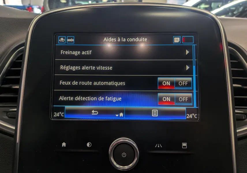 Écran central tactile du Renault Grand Scénic IV affichant les aides à la conduite avec options activées, vue frontale.