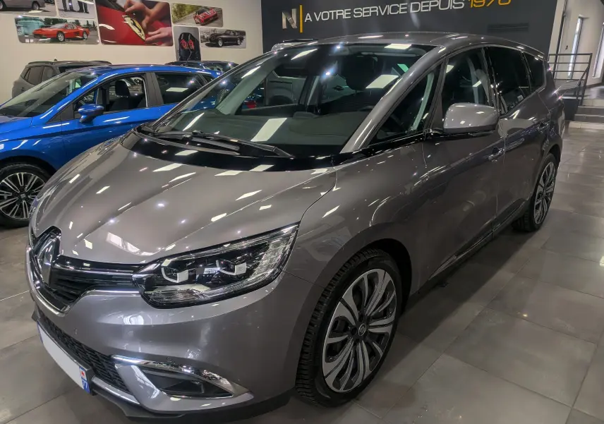 Renault Grand Scénic IV gris Cassiopé en 3/4 avant droit, avec jantes alliage et éclairage LED showroom.