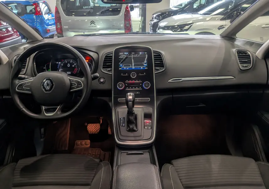 Vue intérieure frontale du tableau de bord et console centrale du Renault Grand Scenic IV TCe 140 Gris Cassiopé, avec écran tactile et volant multifonction.