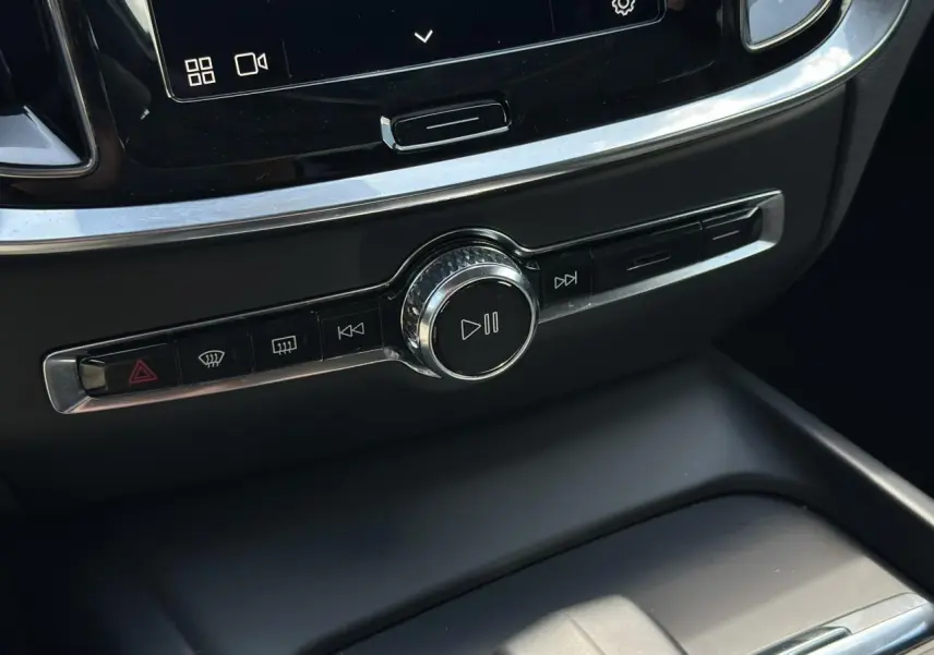 Détail de la console centrale noire de la Volvo S60 2024 avec commandes multimédia et bouton de lecture.
