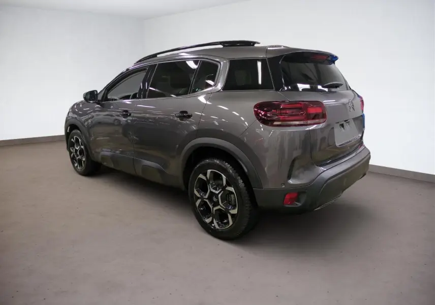 Vue 3/4 arrière droite d'un Citroën C5 Aircross gris Platinium avec jantes alliage et vitres surteintées.