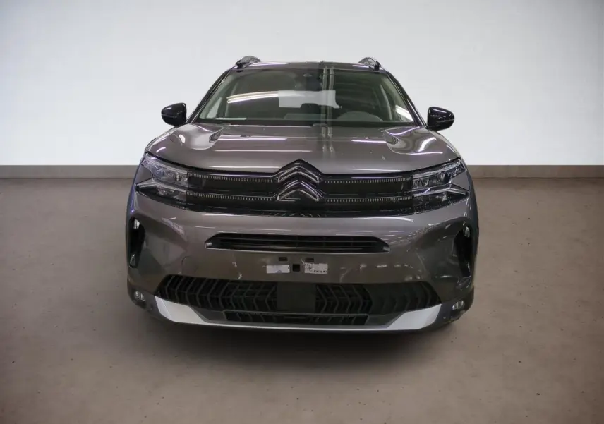 Vue frontale d'un Citroën C5 Aircross Hybrid 145 gris Platinium avec calandre noire et phares LED fins.