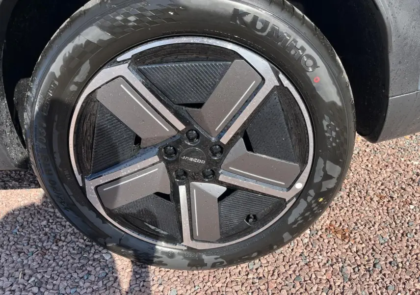 Gros plan sur la roue avant droite gris olive du JAECOO J7 1.5 SHS-P avec jante au design géométrique moderne.