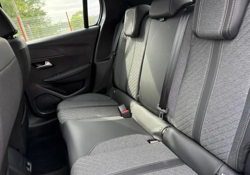 Vue intérieure sur la banquette arrière en tissu gris et cuir noir de la Peugeot 208 1.2 100ch Allure 2025.