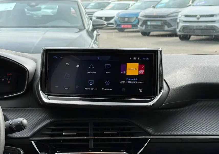 Vue intérieure centrée sur l'écran tactile du tableau de bord de la Peugeot 208 gris Artense, avec détails carbone.