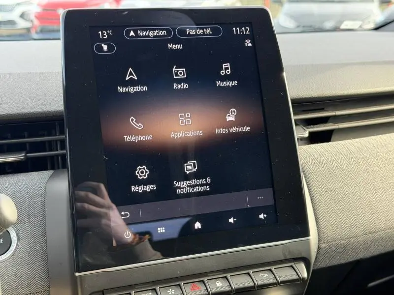 Écran tactile central de la Renault Clio rouge Flamme 2025 affichant le menu multimédia et navigation.