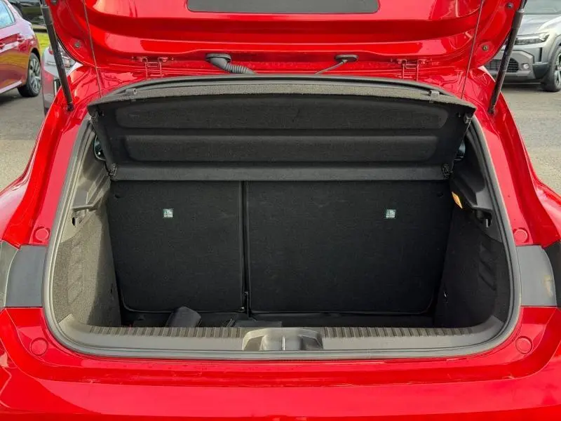 Coffre ouvert vu de l'arrière d'une Renault Clio Rouge Flamme, montrant l'espace de chargement et la tablette cache-bagages.