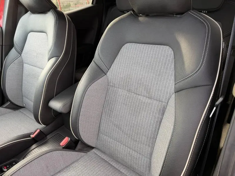 Gros plan sur les sièges avant gris et noir en textile et TEP du Renault Clio 1.0 Eco-G 100ch Techno 2025 Rouge Flamme.