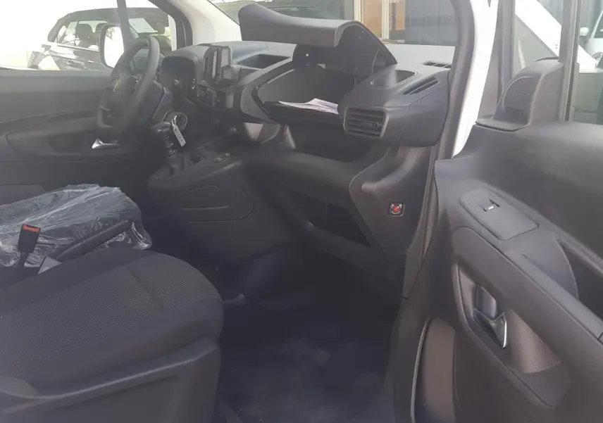 Vue intérieure côté droit du poste de conduite du Citroën Berlingo blanc 2025 avec volant multifonctions et boîte manuelle.