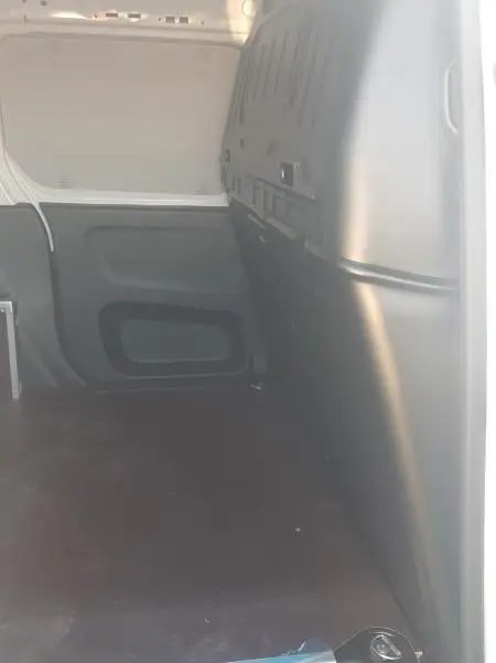 Vue intérieure de la zone de chargement du Citroën Berlingo blanc 2025, montrant l’espace vide et la cloison noire.
