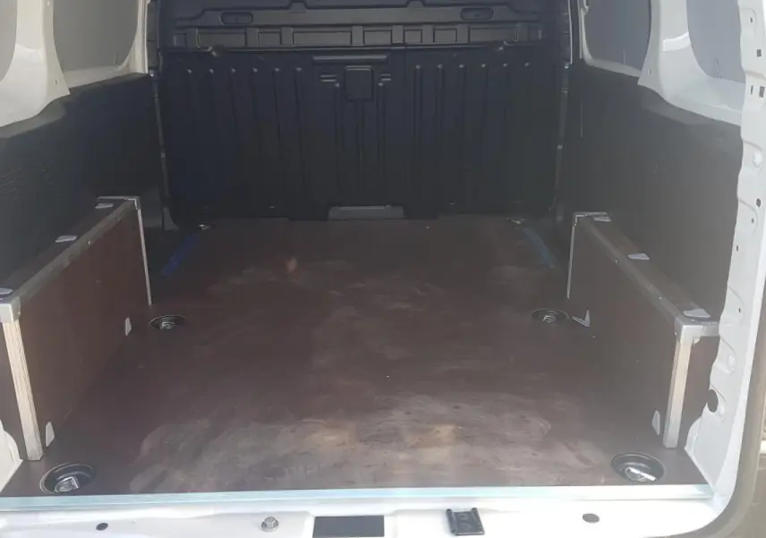 Vue intérieure arrière du Citroën Berlingo blanc 2025, montrant l'espace de chargement vide et les parois latérales.