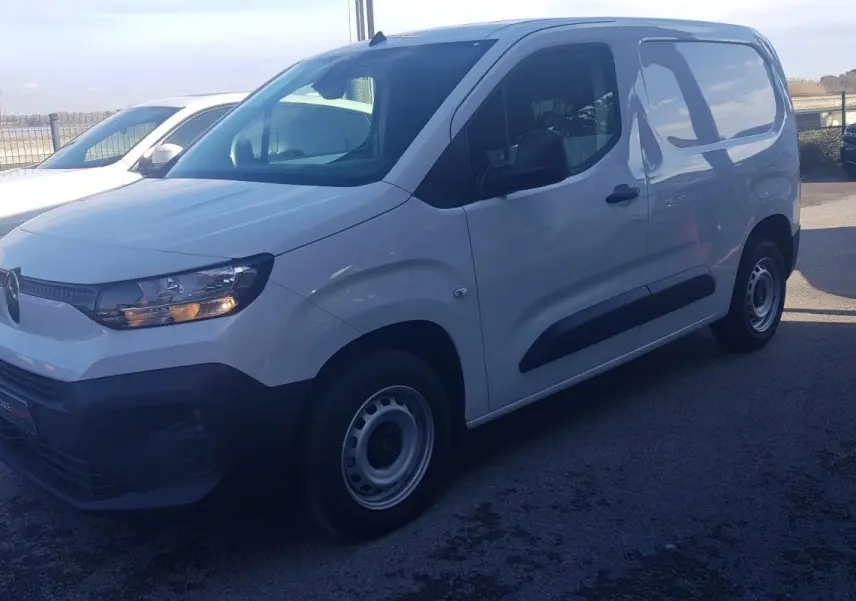 Vue 3/4 avant gauche d’un Citroën Berlingo blanc 2025 avec porte latérale et jantes acier 15 pouces.