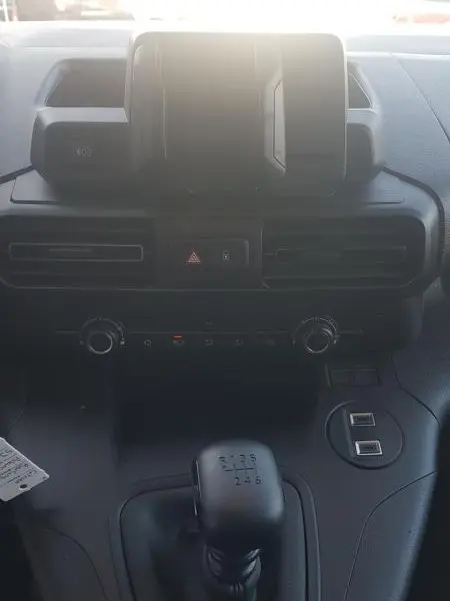 Vue intérieure centrée sur la console centrale et levier de vitesse manuel du Citroën Berlingo blanc 2025.