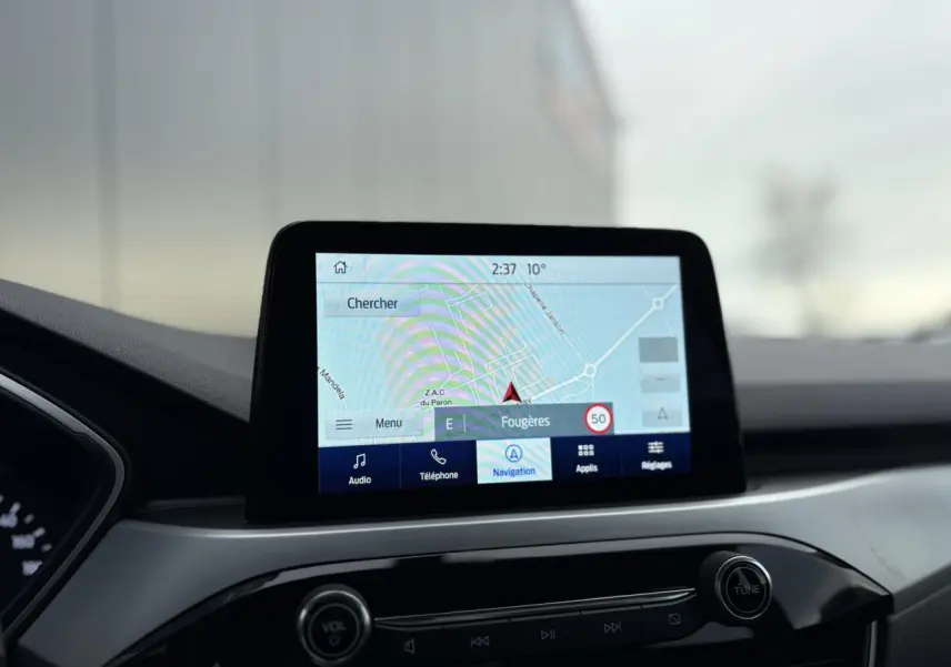 Écran tactile du GPS SYNC 4 du Ford Kuga 2024, vue intérieure centrée sur la console et le tableau de bord.