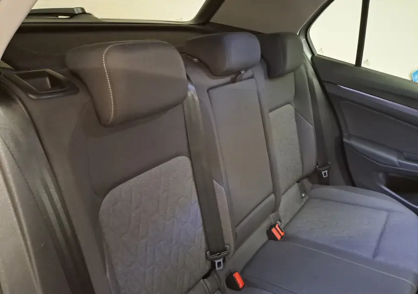 Vue intérieure des sièges arrière en tissu gris avec appuie-têtes et ceintures de sécurité de la Volkswagen Golf 2025.
