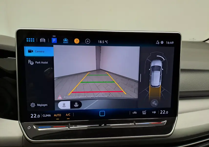 Écran de la caméra de recul de la Volkswagen Golf 1.5 eTSI 116 BVM6 VW Edition montrant l’arrière en intérieur avec lignes de guidage colorées.