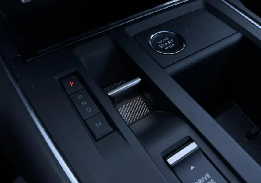 Gros plan sur la console centrale noire du Citroën C5 Aircross Hybrid 2025, montrant le bouton start/stop et la commande de boîte automatique.