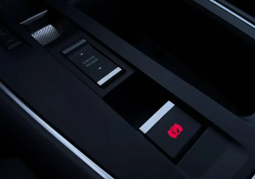 Gros plan sur la console centrale noire du Citroën C5 Aircross Hybrid avec bouton frein électrique illuminé en rouge.
