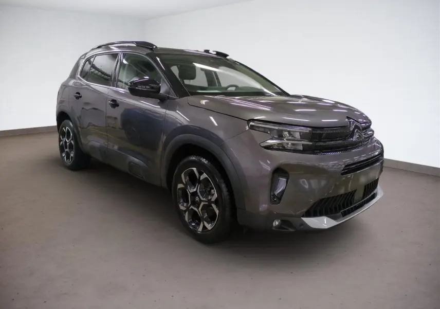 Citroën C5 Aircross Hybrid gris Platinium en 3/4 avant droit, avec jantes alliage bi-ton et barres de toit noires.