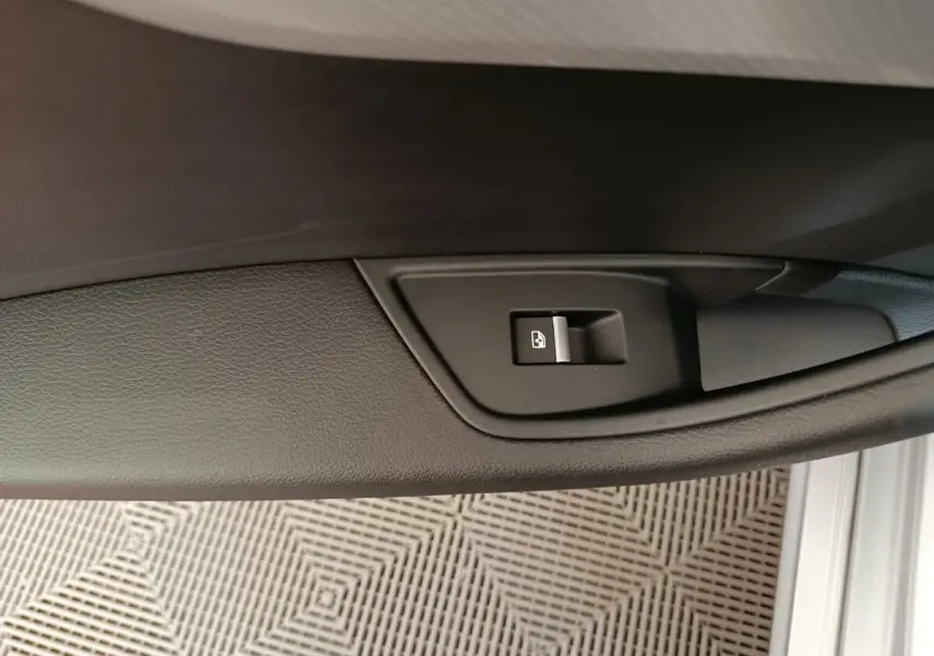 Bouton de verrouillage des portes sur la garniture intérieure noire de la porte côté conducteur d'une Audi A5 gris clair.