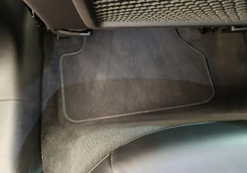Vue rapprochée du sol et tapis noir côté passager arrière d’une Audi A5 gris clair 2019.