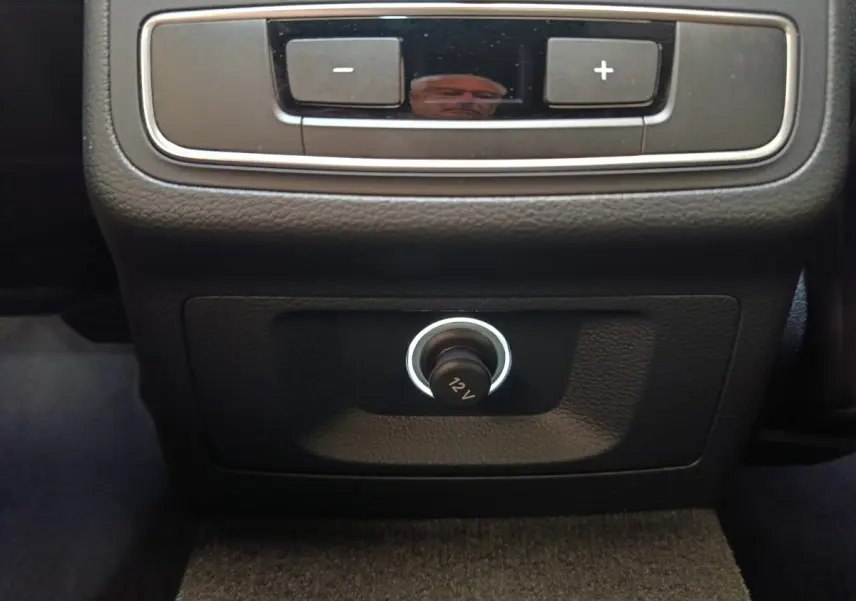 Prise 12V en gros plan sur la console arrière noire de l'Audi A5 40 TFSI 2019, intérieur sombre.