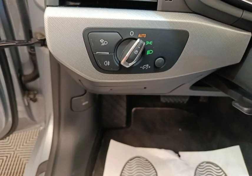 Gros plan sur le panneau de commande des phares à gauche, intérieur gris clair de l'Audi A5 2019.