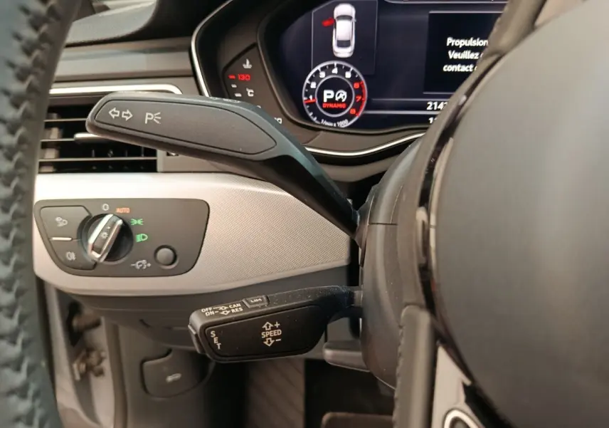 Gros plan sur le volant et le tableau de bord digital noir et gris clair de l'Audi A5 40 TFSI, avec commandes au volant visibles.