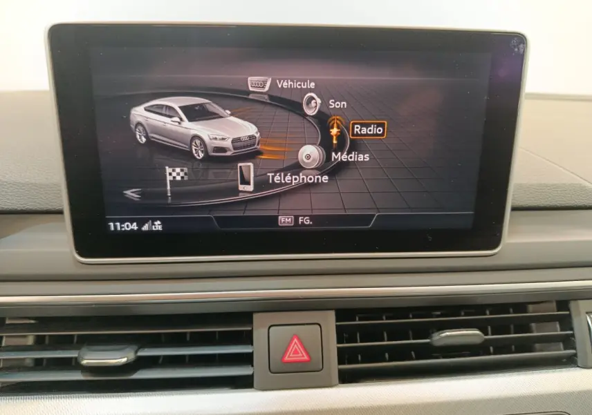 Écran multimédia affichant une Audi A5 gris clair vue de profil dans le menu principal du système de navigation.