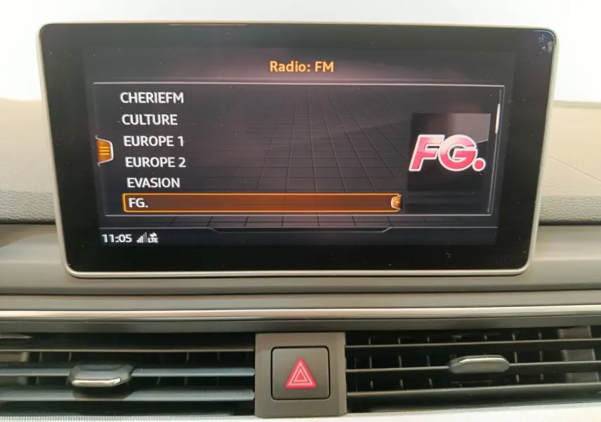 Écran central de l’Audi A5 2019 affichant la liste des stations radio FM, avec tableau de bord gris clair visible.