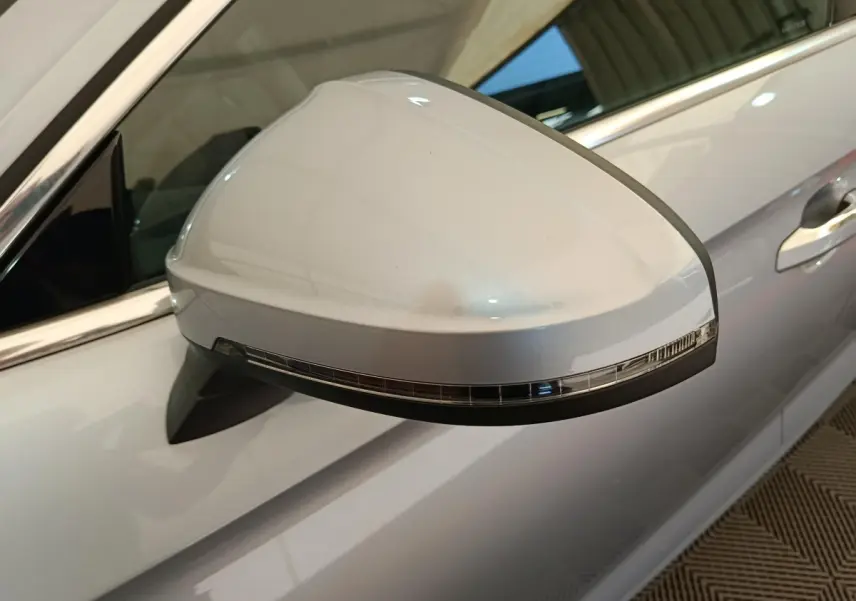 Rétroviseur droit gris clair d'Audi A5 2019 avec clignotant intégré, vue rapprochée sur la portière côté droit.